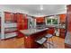 Bright kitchen features wood cabinetry, a center island, and stainless steel appliances at 7883 S Espana Way, Centennial, CO 80016