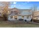 A backyard view of a two-story home with a brick patio and outdoor seating under string lights at 9144 Roadrunner St, Highlands Ranch, CO 80129