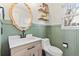 A modern half bath with a decorative mirror, wainscoting, and updated vanity with neutral coloring at 9144 Roadrunner St, Highlands Ranch, CO 80129