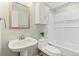 Neutral bathroom with a pedestal sink, a framed mirror, and a shower-tub combo at 9144 Roadrunner St, Highlands Ranch, CO 80129