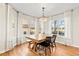 Bright dining room featuring a modern chandelier, light hardwood floors and many windows with natural light at 9144 Roadrunner St, Highlands Ranch, CO 80129