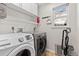Functional laundry room featuring modern washer and dryer with white cabinets for optimal storage at 9144 Roadrunner St, Highlands Ranch, CO 80129