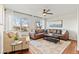 Bright living room with a brown leather couch, area rug, large windows, and natural light at 9144 Roadrunner St, Highlands Ranch, CO 80129