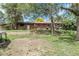 Expansive backyard featuring a brick house with mature trees providing shade and a grassy lawn at 8660 De Soto St, Denver, CO 80229