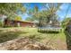 A spacious backyard with a trampoline, a brick house and mature trees creating a relaxing outdoor space at 8660 De Soto St, Denver, CO 80229
