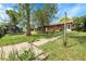 Lush backyard with mature trees and a well-maintained lawn, providing a serene and private outdoor space at 8660 De Soto St, Denver, CO 80229