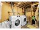 Unfinished basement with exposed ceiling, two white appliances, and a concrete floor at 8660 De Soto St, Denver, CO 80229