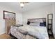 A bedroom with a ceiling fan, wood floors and a large bed at 8660 De Soto St, Denver, CO 80229
