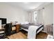 A bedroom with a double bed, small desk, wood floors and light colored walls at 8660 De Soto St, Denver, CO 80229