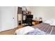 A bedroom with a double bed, small desk, wood floors and light colored walls at 8660 De Soto St, Denver, CO 80229