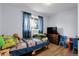 A colorful bedroom with wood floors, a window and blue curtains at 8660 De Soto St, Denver, CO 80229
