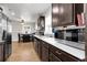 A kitchen with dark wood cabinetry, stainless steel appliances, white countertops and hardwood floors at 8660 De Soto St, Denver, CO 80229