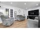 Bright living room featuring neutral walls, wood floors, and comfortable seating with a large tv at 8660 De Soto St, Denver, CO 80229