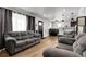Open living space with gray couches, wood floors, and a view into dining area at 8660 De Soto St, Denver, CO 80229