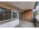 View of the brick-walled balcony with concrete flooring and string lights at 1350 Josephine St # 208, Denver, CO 80206