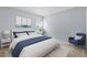 Cozy bedroom with a queen bed, side tables, a blue armchair, and light blue walls at 381 Mountain Cloud Cir, Highlands Ranch, CO 80126
