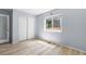 Bedroom featuring a double closet, window, light blue walls, and wood-look flooring at 381 Mountain Cloud Cir, Highlands Ranch, CO 80126