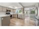 Well-lit kitchen with stainless steel appliances, hardwood floors and an adjacent sunroom at 381 Mountain Cloud Cir, Highlands Ranch, CO 80126