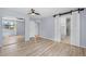 Spacious bedroom with laminate flooring, mirrored closet, and barn door leading to bathroom at 381 Mountain Cloud Cir, Highlands Ranch, CO 80126