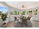 Bright sun room with large windows, ceiling fan, and a round table with four chairs at 381 Mountain Cloud Cir, Highlands Ranch, CO 80126