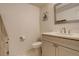 Well-lit half bathroom featuring a modern sink, toilet, and vanity at 3785 S Benton Way, Denver, CO 80235