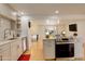 Updated kitchen features an oven and stove, stainless steel appliances, and easy access to the living area at 3785 S Benton Way, Denver, CO 80235