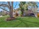 Spacious backyard with mature trees, a green lawn, and partial brick exterior at 3785 S Benton Way, Denver, CO 80235