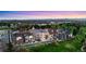 Scenic aerial view of a vibrant neighborhood with a golf course, pond and mountain backdrop at sunset at 4625 W 50Th Ave # 309, Denver, CO 80212
