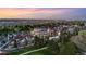 Stunning aerial view of a vibrant community with a golf course, lake and mountain backdrop at sunset at 4625 W 50Th Ave # 309, Denver, CO 80212