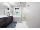 Bright bathroom with white marble tiled walls, dark cabinets, and shower with glass door at 4625 W 50Th Ave # 309, Denver, CO 80212