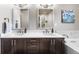 Bathroom with a double vanity sink, dark cabinets, and a large mirror at 4625 W 50Th Ave # 309, Denver, CO 80212