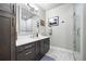 Bright bathroom featuring a glass enclosed shower, modern cabinets, and a large mirror at 4625 W 50Th Ave # 309, Denver, CO 80212
