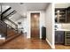 Entryway featuring hardwood floors, a staircase, and a view into a modern kitchen area with a wine cooler at 4625 W 50Th Ave # 309, Denver, CO 80212