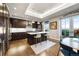 Modern kitchen boasts dark wood cabinetry, white countertops, stainless steel appliances, and a central island with bar seating at 4625 W 50Th Ave # 309, Denver, CO 80212