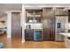 Kitchen area featuring a wine cooler, dark wood cabinets, stainless steel refrigerator, and white marble backsplash at 4625 W 50Th Ave # 309, Denver, CO 80212