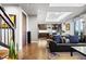 Open-concept living room with dark wood floors, a leather sofa, and a view into the modern kitchen at 4625 W 50Th Ave # 309, Denver, CO 80212
