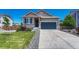 Charming home featuring gray siding, stone accents, well-maintained landscaping, and a two-car garage at 177 Vista Cliff Cir, Castle Rock, CO 80104