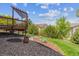 Well-maintained backyard with a deck, stone area, and lush green landscaping at 10448 Kicking Horse Dr, Littleton, CO 80125