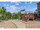 Backyard with a wood deck with pergola, walkway, and a variety of trees, shrubs, and bushes at 10448 Kicking Horse Dr, Littleton, CO 80125