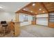 Basement includes a knotty pine bar, cabinets, shelving, and carpeted living space, with a window and neutral walls at 10448 Kicking Horse Dr, Littleton, CO 80125