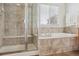 Bathroom featuring a walk-in shower, soaking tub, neutral tile, and a window for natural light at 10448 Kicking Horse Dr, Littleton, CO 80125