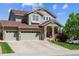 Charming two-story home with a three-car garage, attractive stone accents, and well-maintained front yard at 10448 Kicking Horse Dr, Littleton, CO 80125