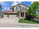 Charming two-story home with a three-car garage, lush lawn, and a welcoming front porch at 10448 Kicking Horse Dr, Littleton, CO 80125