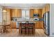 Spacious kitchen with wood cabinets, stainless steel appliances, and island seating at 10448 Kicking Horse Dr, Littleton, CO 80125