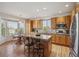Well-lit kitchen with wood cabinets, an island with seating, and a cozy breakfast nook at 10448 Kicking Horse Dr, Littleton, CO 80125