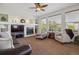Cozy living room featuring a fireplace, large windows, and comfortable seating at 10448 Kicking Horse Dr, Littleton, CO 80125