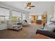 Open-concept living room with large windows, neutral tones, and a seamless flow to the kitchen at 10448 Kicking Horse Dr, Littleton, CO 80125