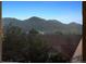 Scenic mountain views from a bright window overlooking treetops and rooftops at 10448 Kicking Horse Dr, Littleton, CO 80125