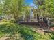 Backyard with a deck, lush lawn, mature trees, and stairs at 848 Huntington Pl, Highlands Ranch, CO 80126