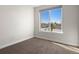 Minimalist bedroom with large window offering neighborhood view and neutral color scheme at 4917 Lowell Blvd # 105, Denver, CO 80221